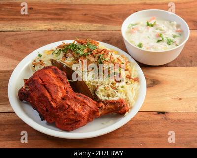 Poulet Tandoori et poulet Biryani servis sur fond de bois rustique.Plats et hors-d'œuvre de cuisine indienne, sélection Banque D'Images