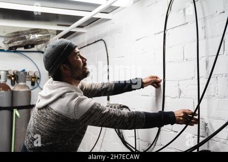 Travailleur travaillant avec des bouteilles d'oxygène au centre de plongée - concept industriel d'usine - Focus en face Banque D'Images