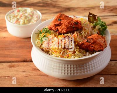 Poulet Tikka Biryani fait de riz Basmati cuit avec des épices de masala, servi avec du yaourt, concentré sélectif Banque D'Images