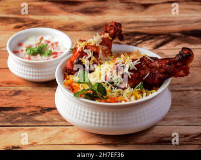 Poulet Tandoori Biryani à base de riz Basmati cuit avec des épices de masala, servi avec du yaourt, concentré sélectif Banque D'Images