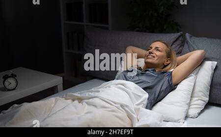 Smiling woman in bedroom Banque D'Images
