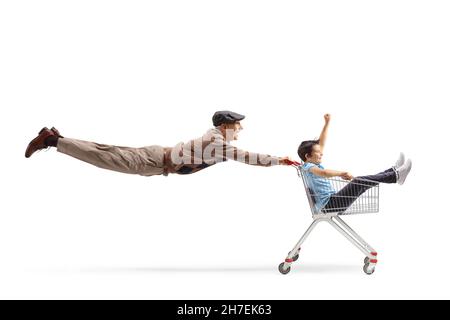 Prise de vue en longueur d'un homme âgé volant et poussant un chariot avec un enfant à l'intérieur isolé sur fond blanc Banque D'Images