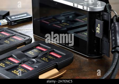 Cartes SD Transcend 700S UHS-II de 32 Go dans un boîtier PolarPro Slate avec caméra Leica TL2 sur table en bois Banque D'Images