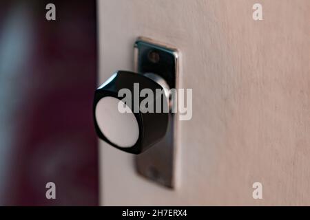 Ancienne poignée arrondie blanche et noire de porte intérieure.Verrouillage à bille.À l'intérieur.Bouton de porte en plastique.Soviétique Banque D'Images