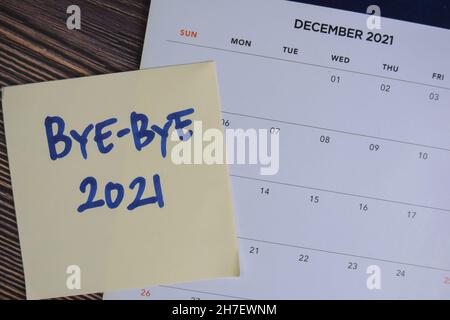 Bye-Bye 2021 écrire sur les notes adhésives et le calendrier isolé sur la table en bois. Banque D'Images