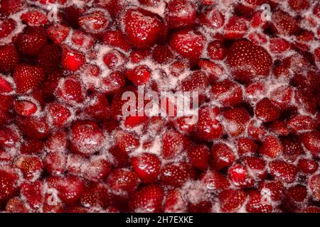 Processus de fabrication de confiture de fraises maison.Sirop doux rouge bouillant sur la cuisinière de près.La confiture de fraises a l'air très appétissante. Banque D'Images