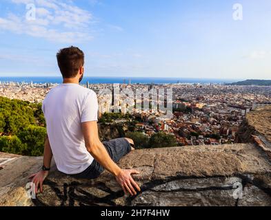 Un jeune homme profitant de la vue de Bunkers del Carmel sur la ville de Barcelone, Espagne. Banque D'Images