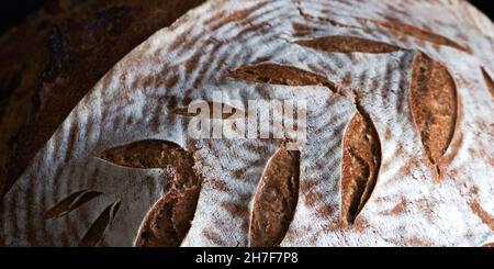 Pain noir rond maison avec croûte de farine et pointe peinte en gros plan Banque D'Images