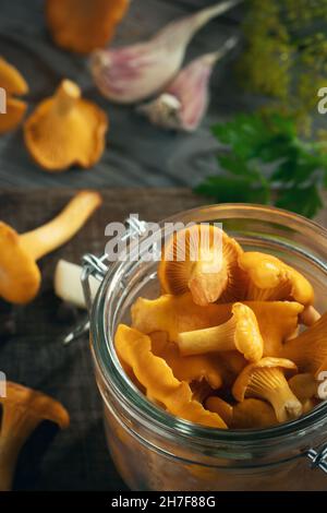 Conserver les chanterelles dans un pot aux épices et aux herbes.Pickling de champignons sauvages comestibles.Image verticale. Banque D'Images