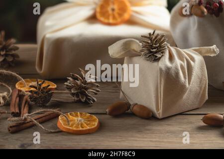 Concept de noël zéro déchet. Emballé dans des cadeaux et des décorations en tissu naturel à partir de matériaux naturels sur une table en bois. Banque D'Images