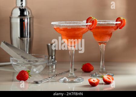 Cocktails maison aux fraises et margaritas frais avec outils de bar sur la table.Préparation de cocktails rafraîchissants en été. Banque D'Images