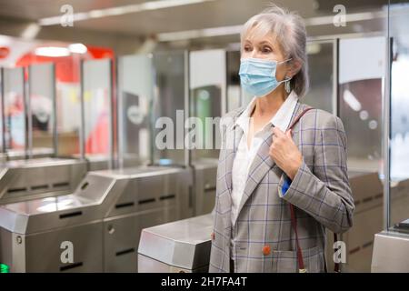 Femme âgée dans un masque à l'entrée de la station de métro Banque D'Images