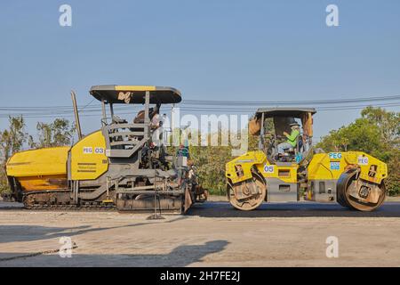 Phayao, Thaïlande - 27 janvier 2021: Travailleur et finisseur d'asphalte et rouleau de route sur la route d'asphalte Banque D'Images