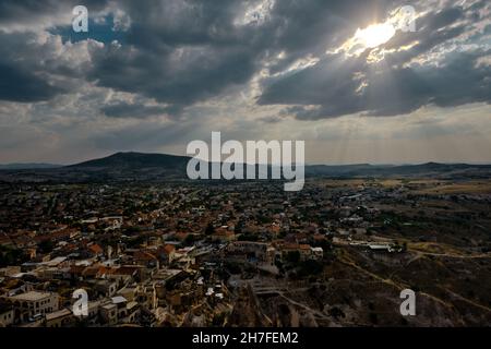 Centre-ville antique de cappadoce depuis le château de bord (uc hisar) avec de nombreuses maisons magnifiques en pierres spéciales et de spectaculaires nuages de ciel et le soleil Banque D'Images