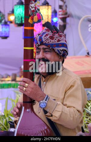 Pune, Maharashtra / Inde - 18 novembre 2021 : chanteur folklorique Rajasthani avec turban et moustache avec un instrument de musique à l'événement du Festival local. Banque D'Images