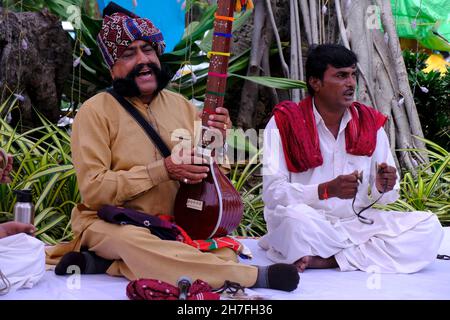 Pune, Maharashtra / Inde - 18 novembre 2021 : chanteur folklorique Rajasthani avec turban et moustache avec un instrument de musique à l'événement du Festival local. Banque D'Images