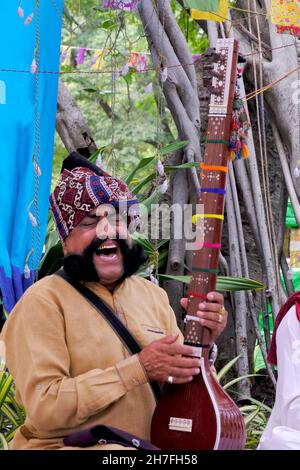 Pune, Maharashtra / Inde - 18 novembre 2021 : chanteur folklorique Rajasthani avec turban et moustache avec un instrument de musique à l'événement du Festival local. Banque D'Images