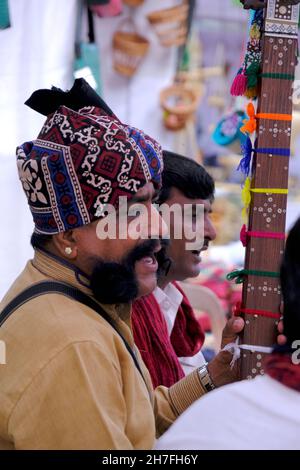 Pune, Maharashtra / Inde - 18 novembre 2021 : chanteur folklorique Rajasthani avec turban et moustache avec un instrument de musique à l'événement du Festival local. Banque D'Images