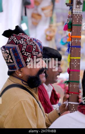 Pune, Maharashtra / Inde - 18 novembre 2021 : chanteur folklorique Rajasthani avec turban et moustache avec un instrument de musique à l'événement du Festival local. Banque D'Images