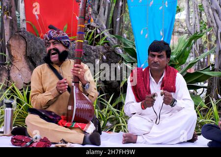 Pune, Maharashtra / Inde - 18 novembre 2021 : chanteur folklorique Rajasthani avec turban et moustache avec un instrument de musique à l'événement du Festival local. Banque D'Images