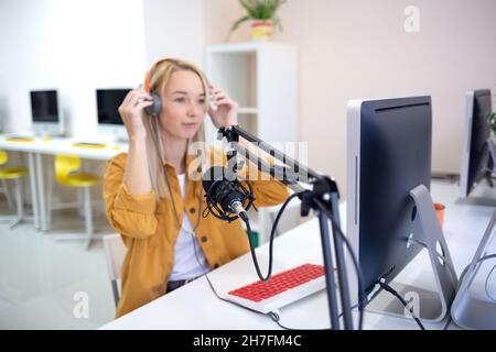 une jeune femme diffuse en streaming tout en étant assise dans un collègue à l'ordinateur. Banque D'Images