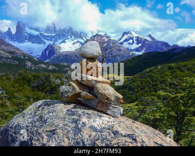 Cairn de pierre sur un grand rocher avec des montagnes rocheuses en arrière-plan Banque D'Images