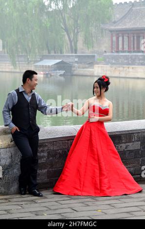 CHINE.PÉKIN.COUPLE DE JEUNES MARIÉS EN FACE DE LA VILLE INTERDITE.PAR TRADITION, LA ROBE DE LA MARIÉE EST ROUGE. Banque D'Images