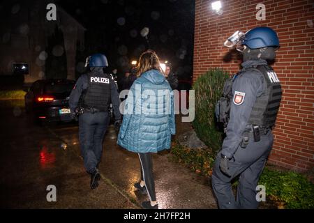 23 novembre 2021, Rhénanie-du-Nord-Westphalie, Gütersloh : un suspect est emmené par des policiers.La police a arrêté plusieurs suspects lors de raids simultanés dans plusieurs pays contre des soi-disant «calmars de bâches».On dit qu'il s'agit de gangs de voleurs qui volent des charges de camions.Photo: Lino Mirgeler/dpa Banque D'Images