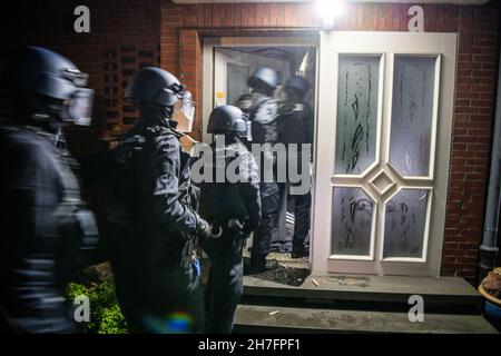 23 novembre 2021, Rhénanie-du-Nord-Westphalie, Gütersloh : les forces de police s'empagent dans une maison pour la rechercher.La police a arrêté plusieurs suspects lors de raids simultanés dans plusieurs pays contre des soi-disant «calmars de bâches».On dit qu'il s'agit de gangs de voleurs qui volent des charges de camions.Photo: Lino Mirgeler/dpa Banque D'Images