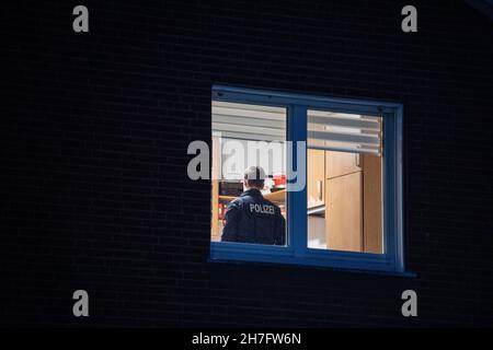 23 novembre 2021, Rhénanie-du-Nord-Westphalie, Gütersloh : un policier se tient dans la salle d'une maison qui a été fouillée par la police.La police a arrêté plusieurs suspects lors de raids simultanés dans plusieurs pays contre des soi-disant «calmars de bâches».On dit qu'il s'agit de gangs de voleurs qui volent des charges de camions.Photo: Lino Mirgeler/dpa Banque D'Images