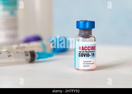 Flacon de petit vaccin avec une étiquette indiquant Covid - 19 Corona virus Vaccine, et une seringue médicale injection avec une goutte de vaccin sur son aiguille, Banque D'Images