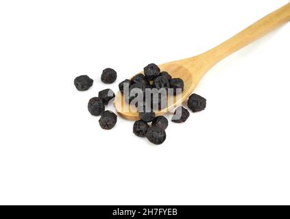 Baies d'aronia séchées dans une cuillère en bois isolée sur fond blanc Banque D'Images