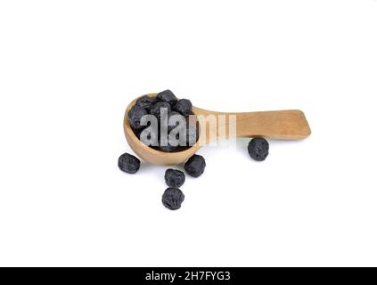 Baies d'aronia séchées dans une cuillère en bois isolée sur fond blanc Banque D'Images
