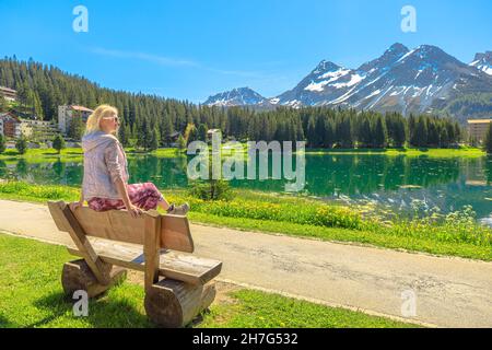 Femme suisse assise sur un banc de parc d'Arosa.Ville et station touristique près du lac Obersee en Suisse.Arosa en bord de lac par la station de téléphérique à Aroser Banque D'Images