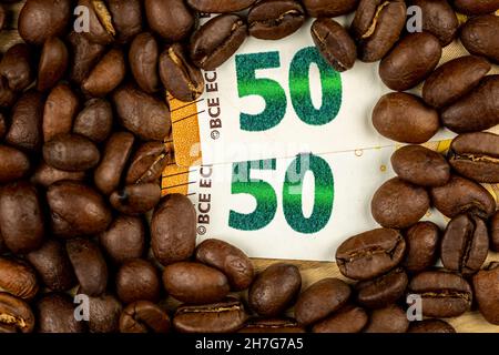 Grains de café rôtis avec facture de 50 euros.Prix élevé du café.Image prise dans une bonne lumière artificielle. Banque D'Images