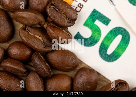 Grains de café rôtis avec facture de 50 euros.Prix élevé du café.Image prise dans une bonne lumière artificielle. Banque D'Images