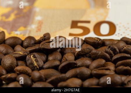 Grains de café rôtis avec facture de 50 euros.Prix élevé du café.Image prise dans une bonne lumière artificielle. Banque D'Images