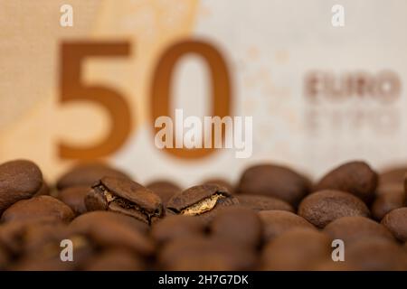 Grains de café rôtis avec facture de 50 euros.Prix élevé du café.Image prise dans une bonne lumière artificielle. Banque D'Images