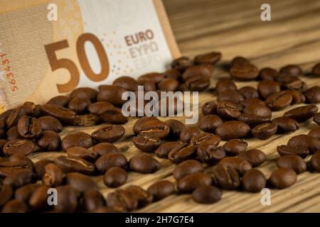 Grains de café rôtis avec facture de 50 euros.Prix élevé du café.Image prise dans une bonne lumière artificielle. Banque D'Images