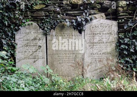 Trois pierres à tête du XIXe siècle poétique encadrées d'herbe et de lierre au périlitre de l'église du parc Stoke Damerel à Plymouth.Une grande partie de l'historique c Banque D'Images