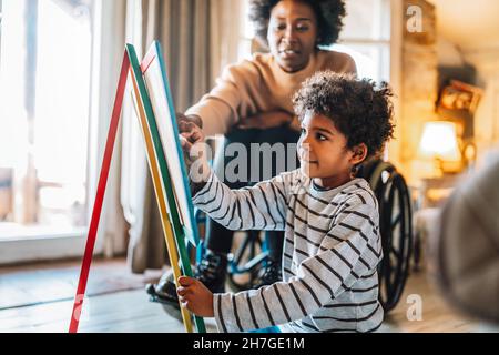 Enfant heureux faisant des exercices de mathématiques avec sa mère ou professeur ensemble. Concept de divertissement pour les gens de l'éducation Banque D'Images