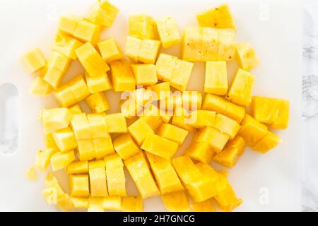 Mise à plat. Nettoyage et coupe un ananas dans les petits morceaux. Banque D'Images