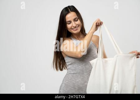 Concept d'écologie.Femme tenant un sac d'épicerie en coton avec des légumes.Sac écologique réutilisable pour les achats.Concept zéro déchet.Style de vie écologique.Isolé Banque D'Images