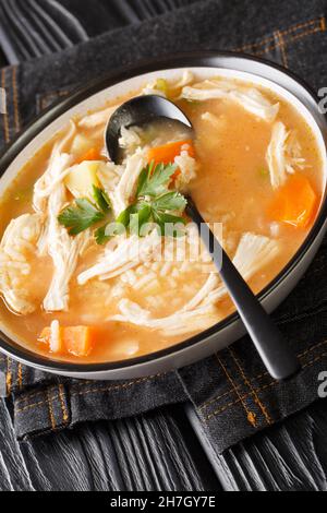 La recette de Canja de galinha est une soupe classique de poulet et de riz qui se trouve dans l'assiette de la table.Verticale Banque D'Images