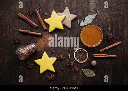 Pain d'épice de Noël en forme d'étoiles, d'épices et de miel sur une table en bois. Banque D'Images