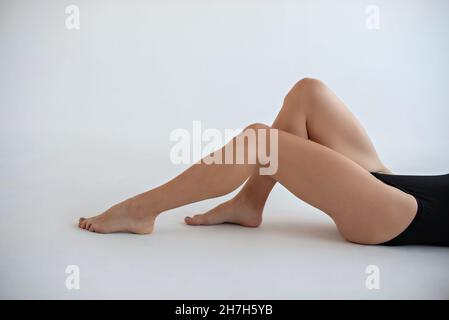 Des jambes féminines lisses sur fond blanc. Mockup pour un tatouage sur la cuisse ou la jambe inférieure. Banque D'Images