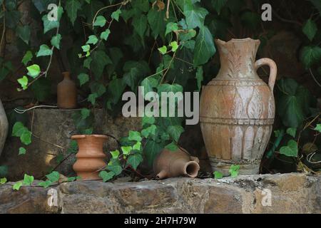 Pots libanais en terre cuite dans le jardin au milieu des feuilles vertes. Banque D'Images