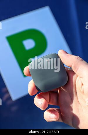 Un jeune conducteur sur le point d'installer une boîte noire télématique d'assurance automobile au Royaume-Uni dans sa nouvelle voiture, qui affiche également des plaques P. Banque D'Images