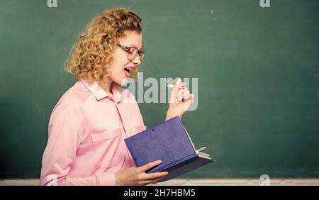 Femme enseignante devant le tableau de surveillance.Passionné par la connaissance.Pédalo tenir le livre et expliquer l'information.Concept d'éducation.Enseignant Banque D'Images