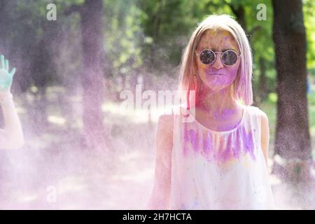 une jeune femme avec une poudre de couleur sèche de peintures holi explose autour d'elle.La fille célèbre le festival des couleurs Holi. Lieu pour le texte Banque D'Images